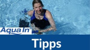 Eine Frau in einem dunklen Badeanzug betreibt Aquafitness und schaut mit Freude und dynamischer Haltung aus dem Wasser eines Schwimmbeckens. Im unteren Bildteil steht auf blauem Untergrund in weißer Schrift "Tipps". Links über dem Schriftzug steht das Logo AQUA IN. Das Bild dient als Blogbeitragsbild für den Blogartikel: "Vom guten Vorsatz zur festen Routine: 6 Tipps für mehr Aquafitness im Alltag".