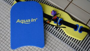 Aquafitness-Kurs in der Nähe: Aquafitness-Ausrüstung mit Schwimmbrett, Auftriebsgürtel, Schwimmbrille am Beckenrand.